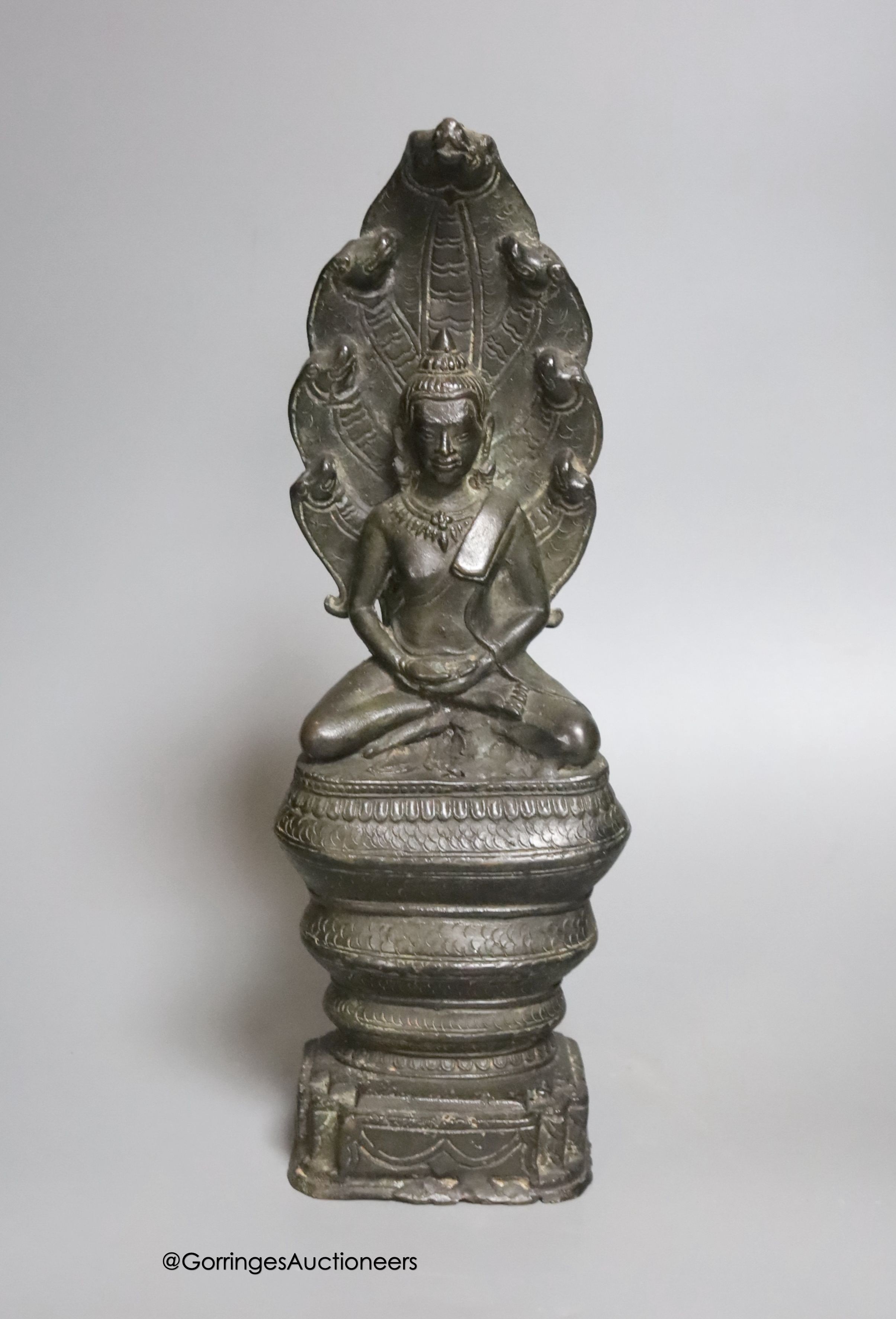 An 18th/19th century Cambodian bronze seated figure of Buddha Shakyamuni and the cobra Mucalinda 33cm